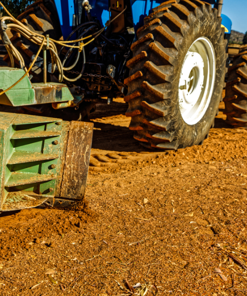 A tractor is parked on a dirt field